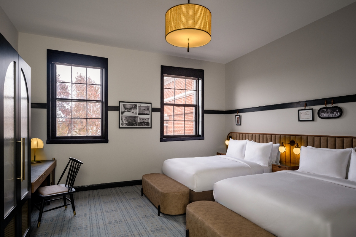 a room with two beds and a chair