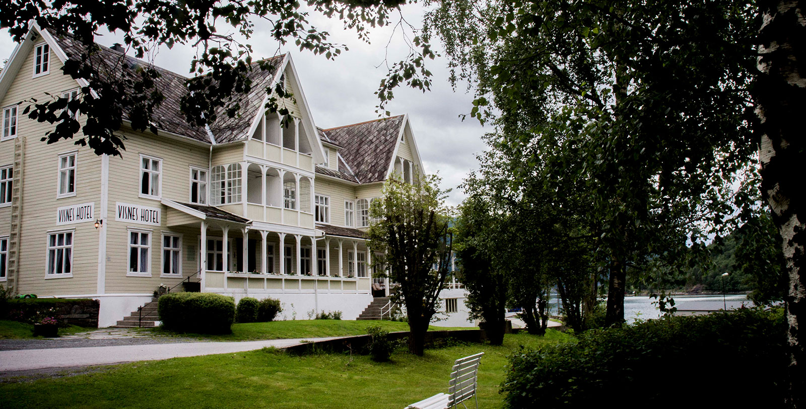a large white house with a lawn and trees