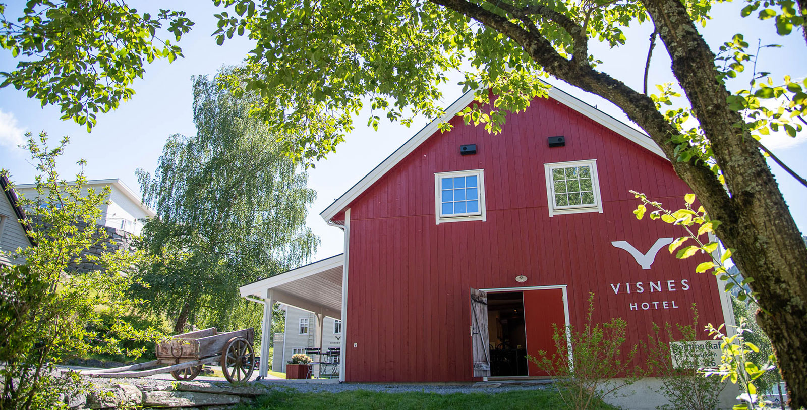 a red barn with a carriage and trees
