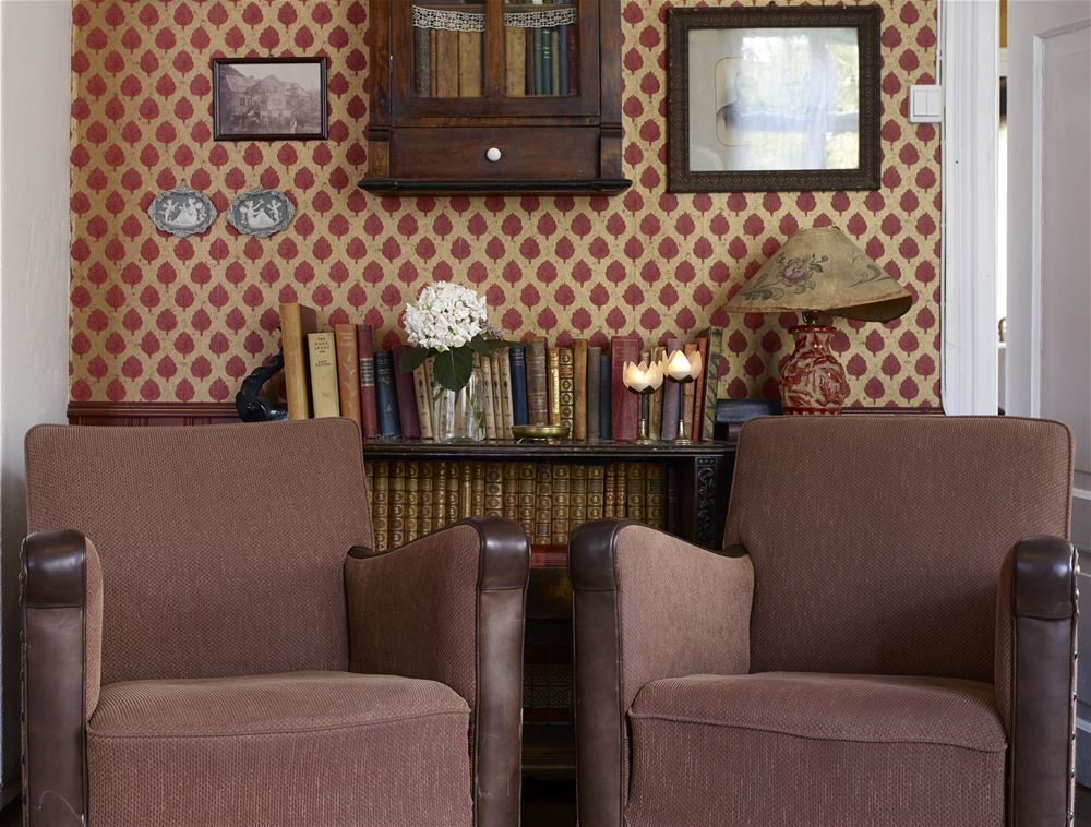 a room with a book shelf and chairs