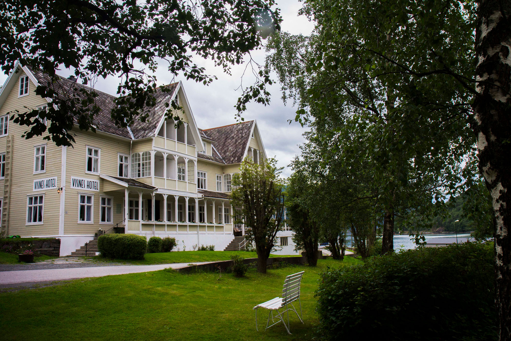 a large house with a lawn and a bench