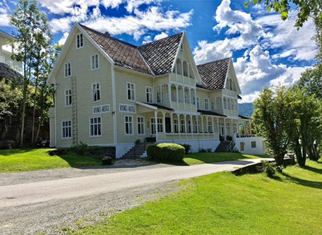 a large house with a driveway and trees