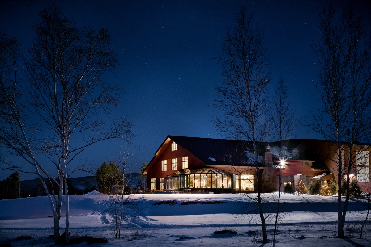 a house with a large building in the snow