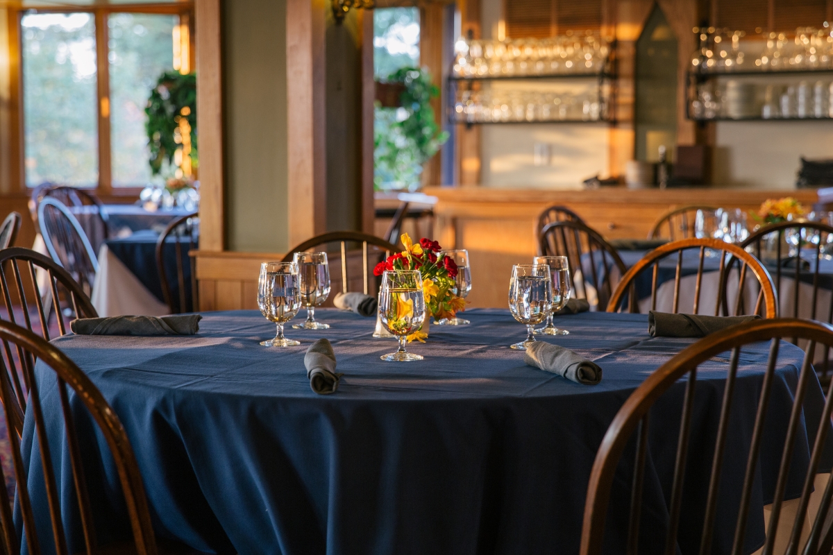 a table set with wine glasses and flowers