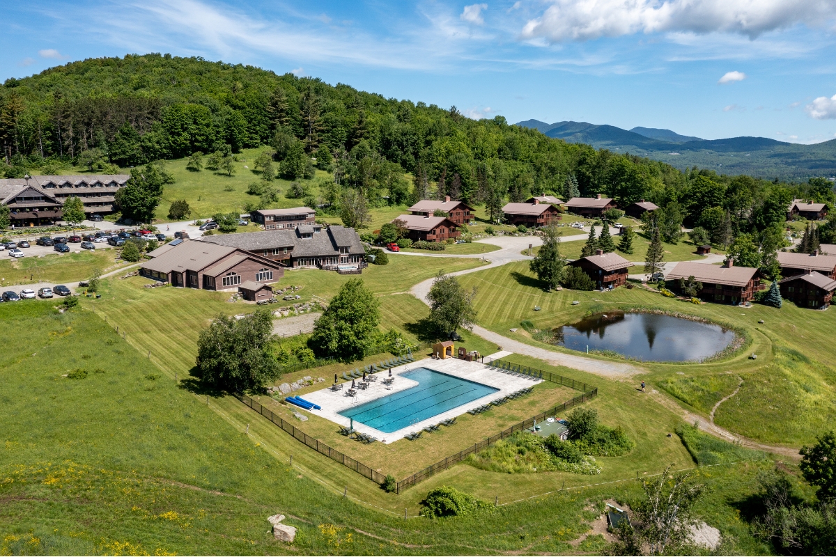 a pool in a grassy area with houses and trees