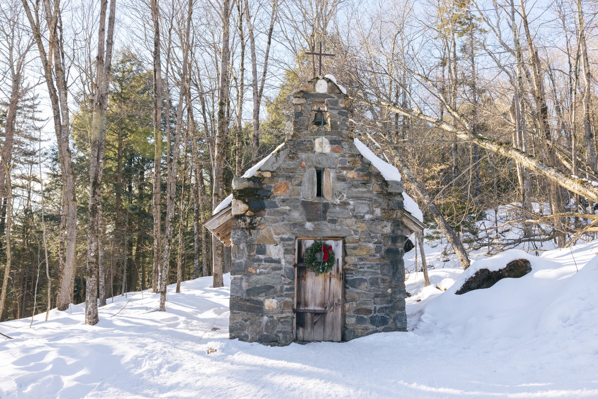 a stone building with a cross on the door
