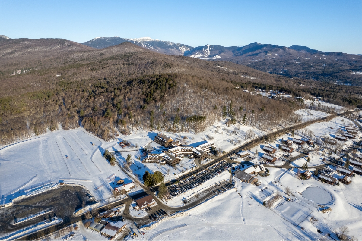 a snowy mountain landscape with buildings and trees