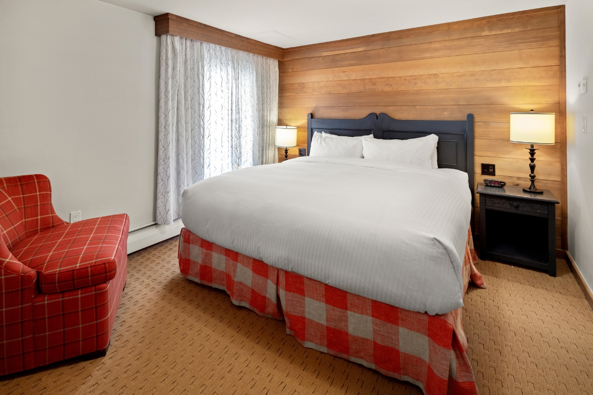 a bed with a red and white checked skirt