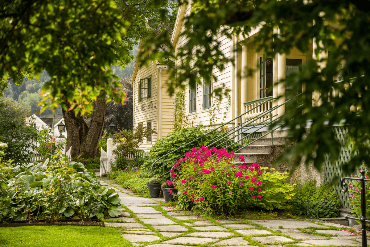 a house with a walkway and flowers