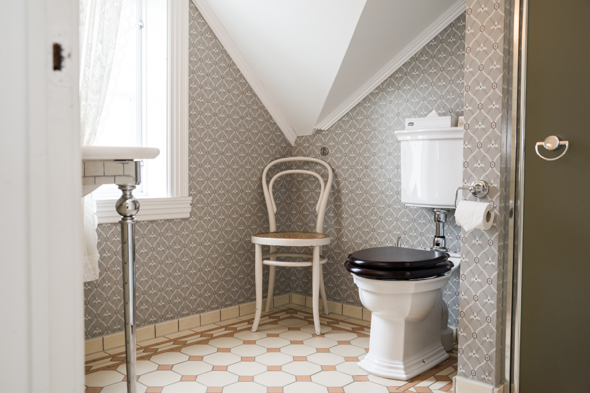 a bathroom with a chair and a toilet