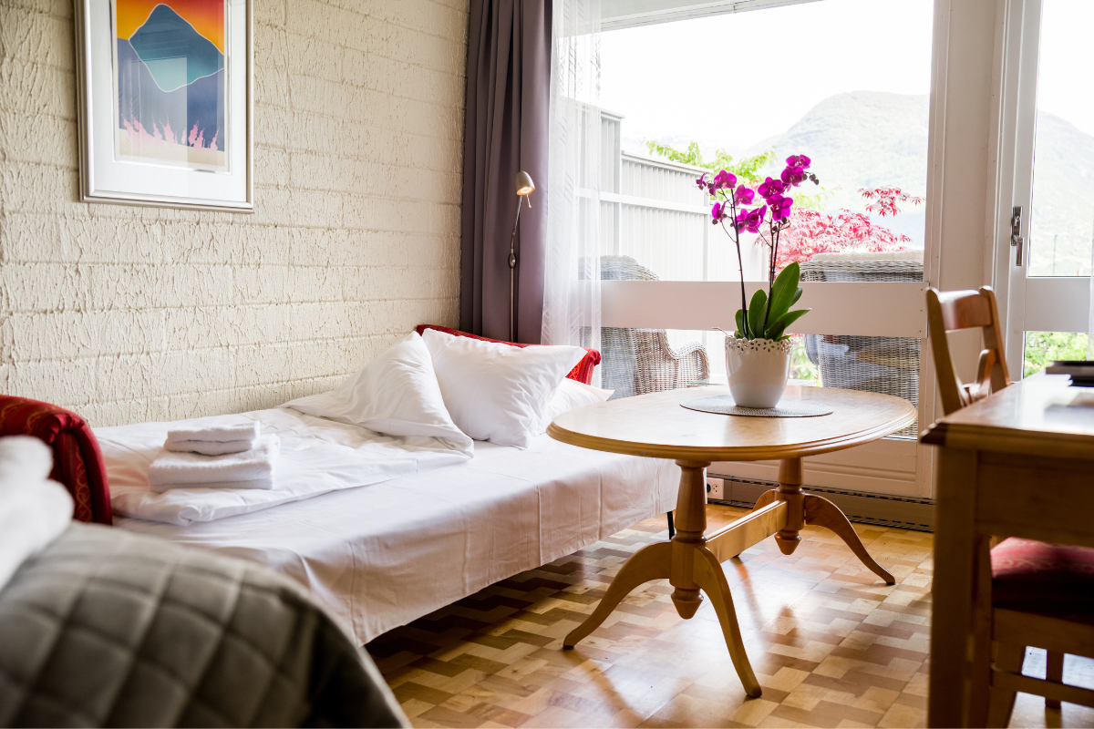a small bed with a table and a plant on it