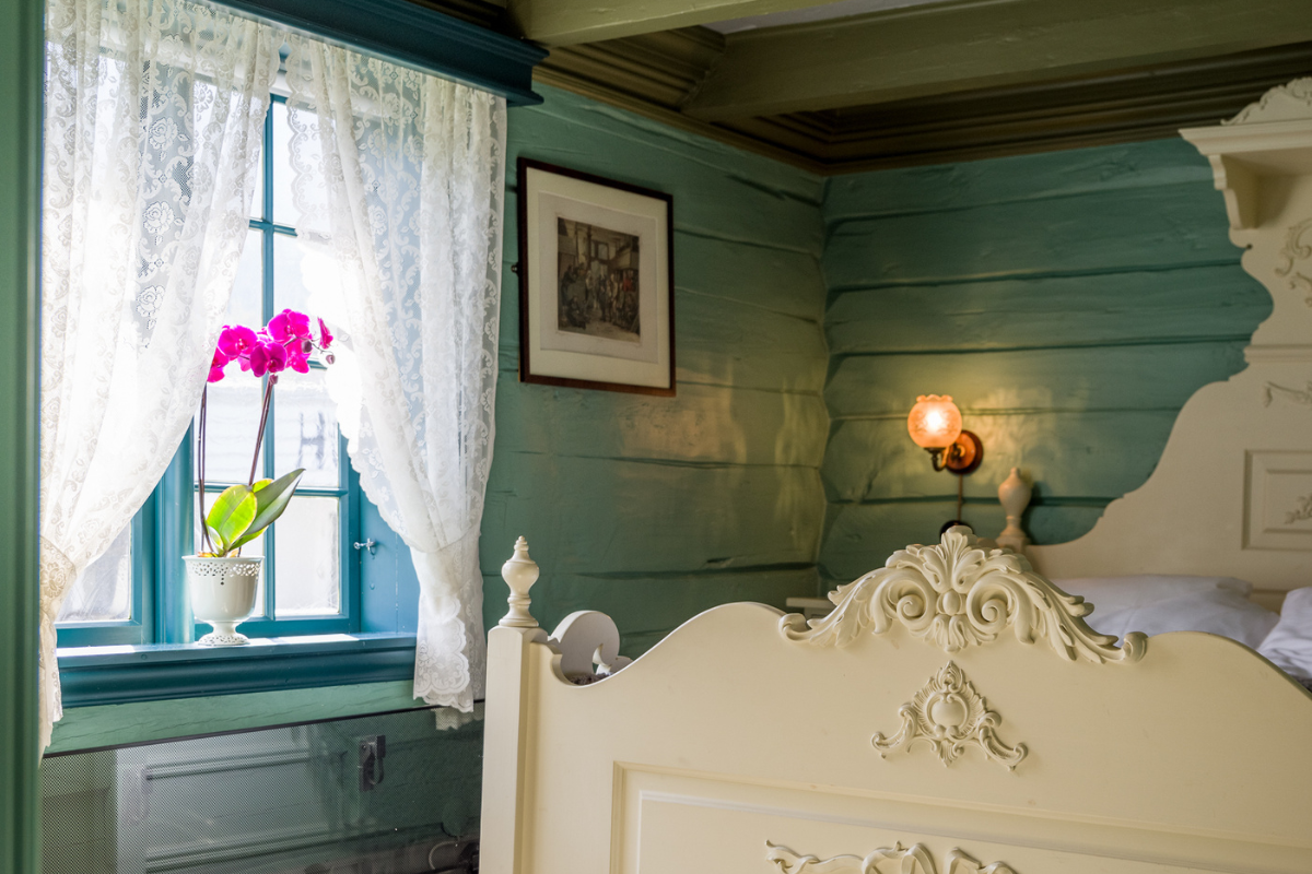 a white bed in a room with a window and a picture