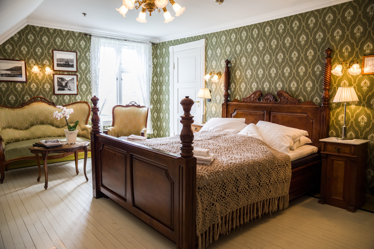 a bedroom with a bed and chairs