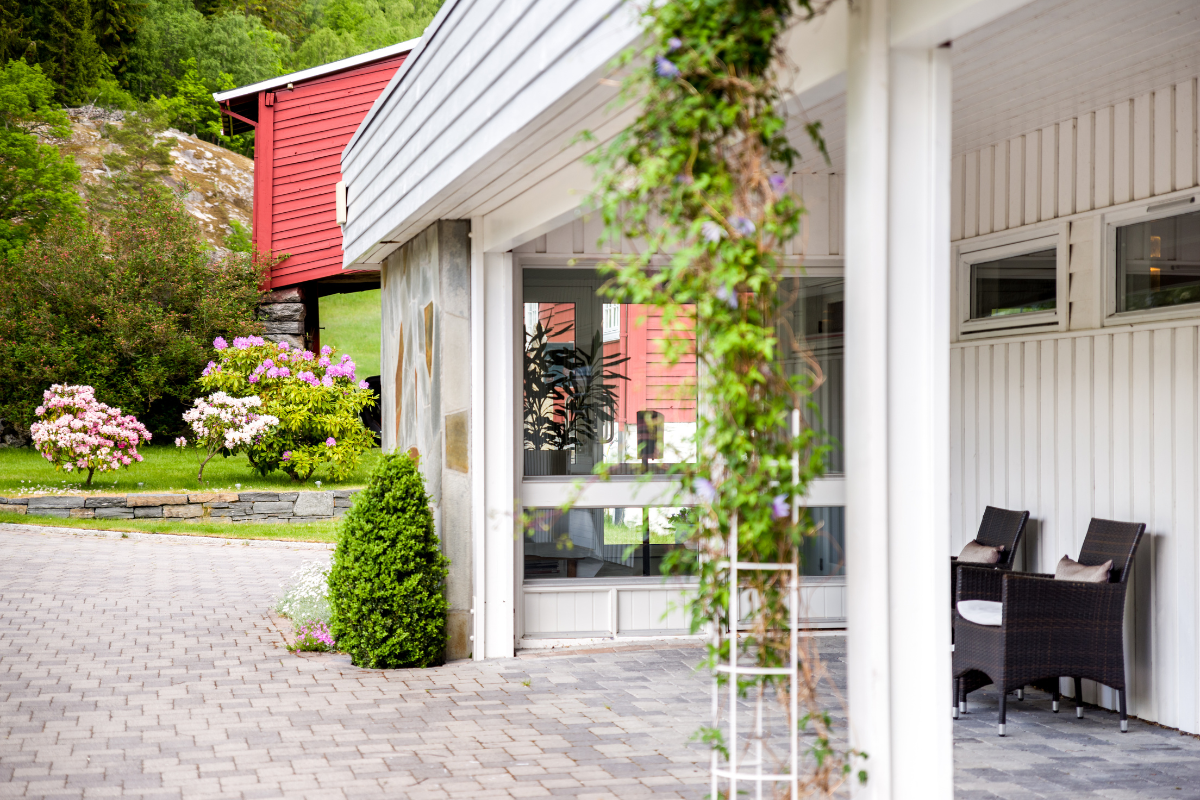 a white building with a brick patio and a brick walkway