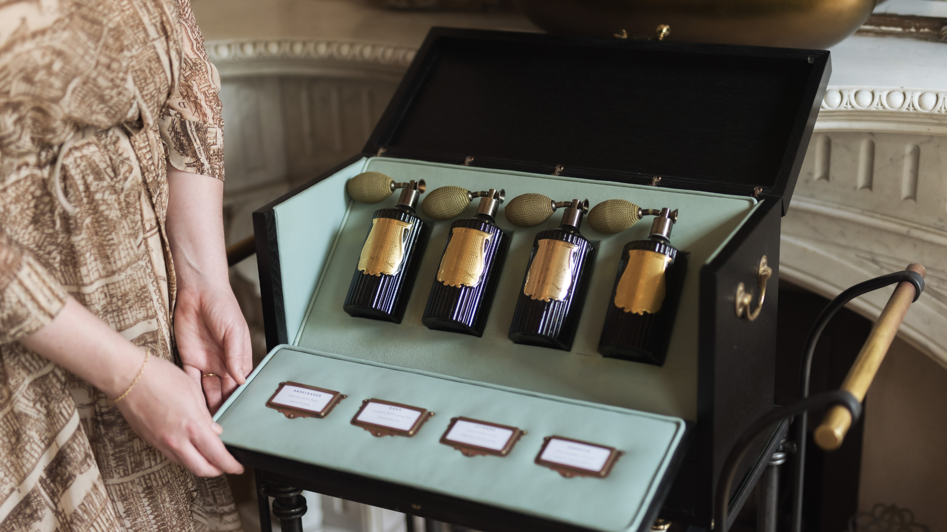 a woman holding a box with bottles of perfume