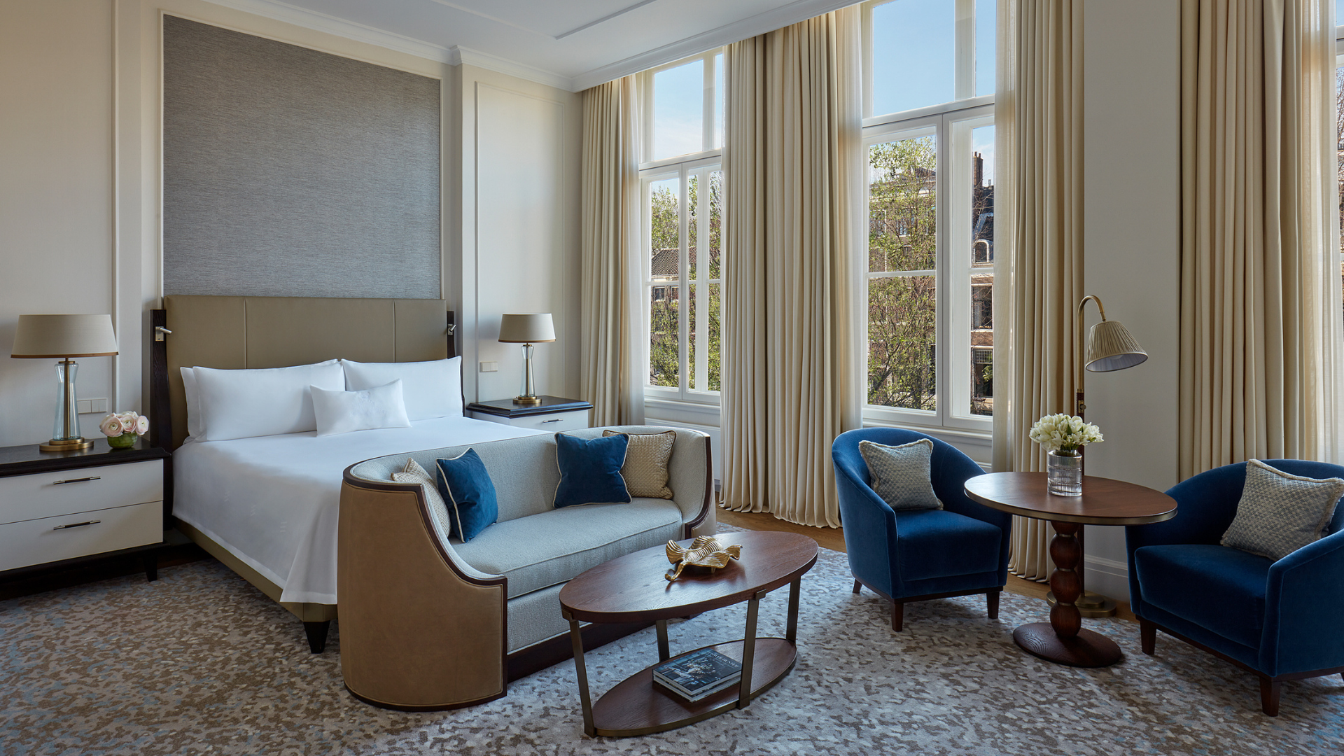 a room with a bed and chairs