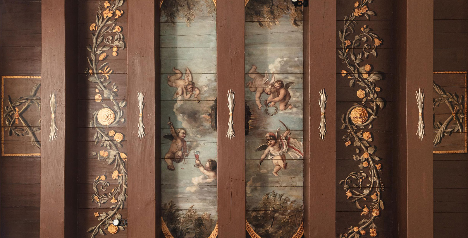 a painted wood paneling with angels and flowers