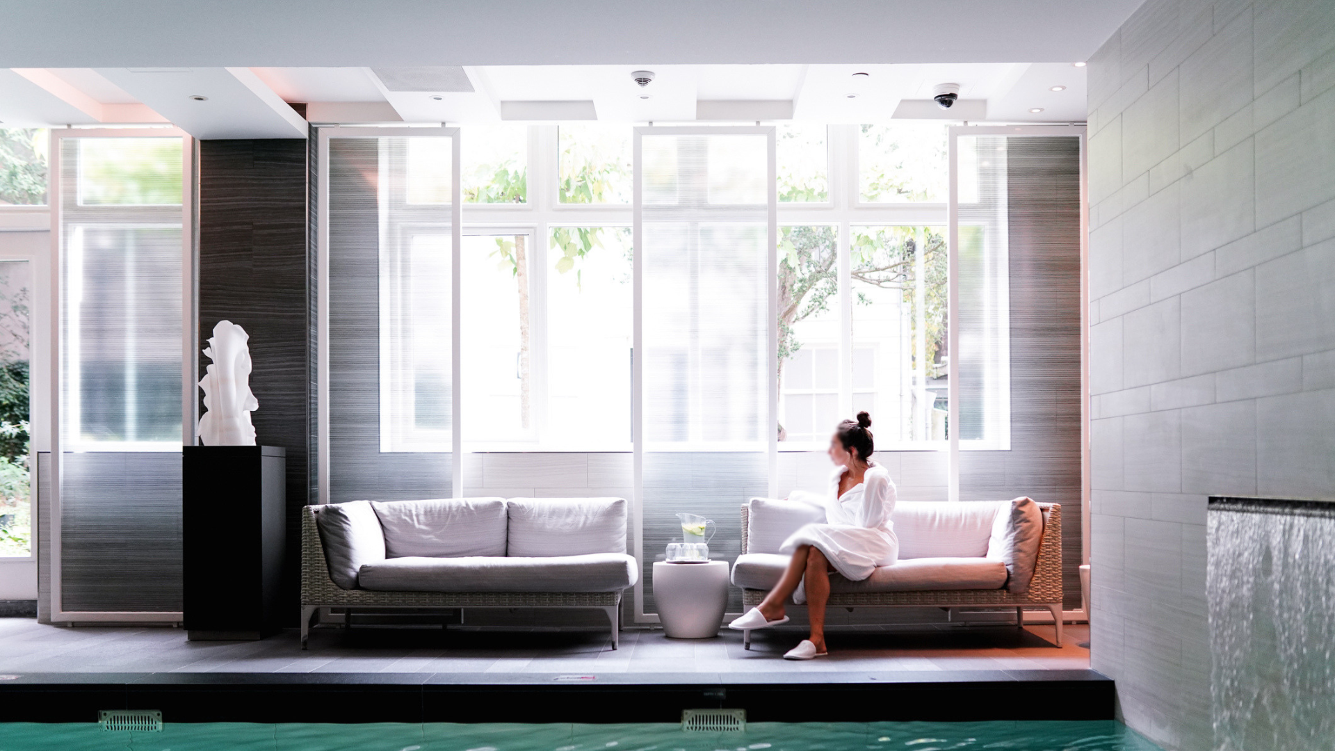 a woman sitting on a couch in a room with a pool