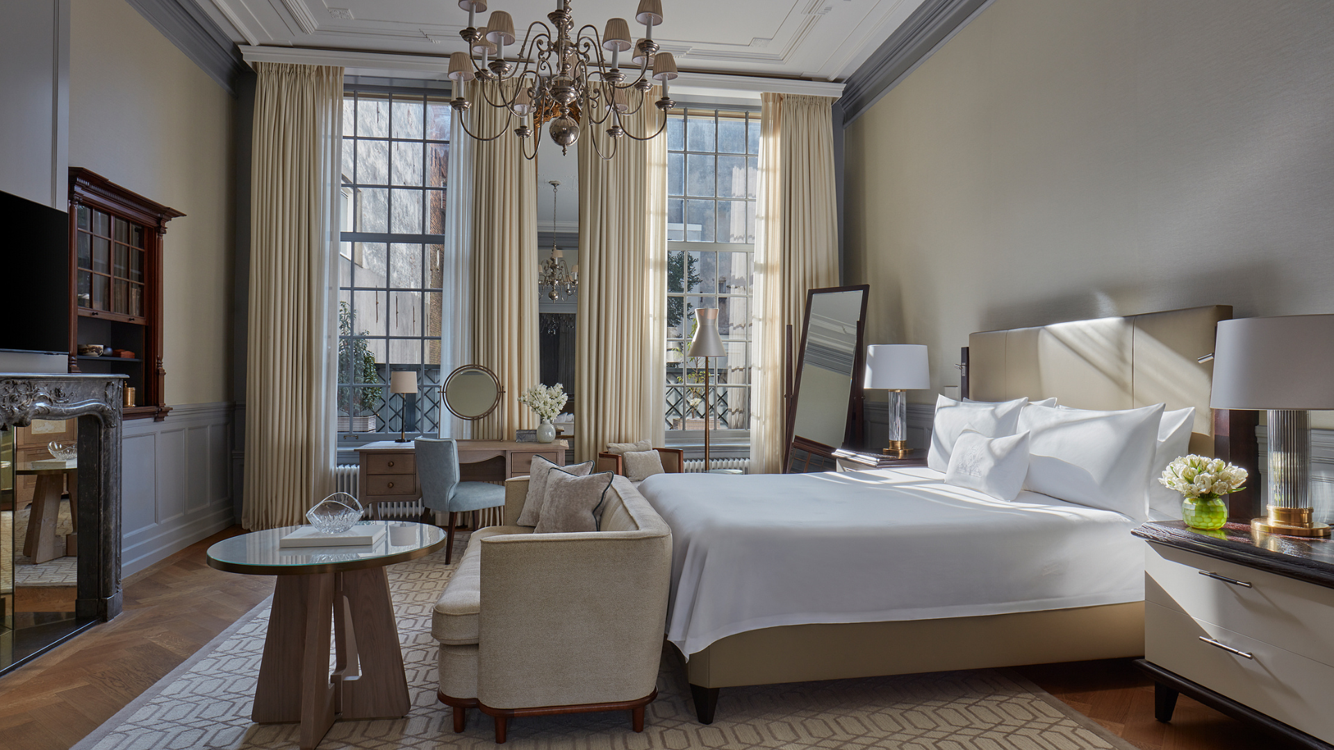 a bedroom with a large bed and a chandelier