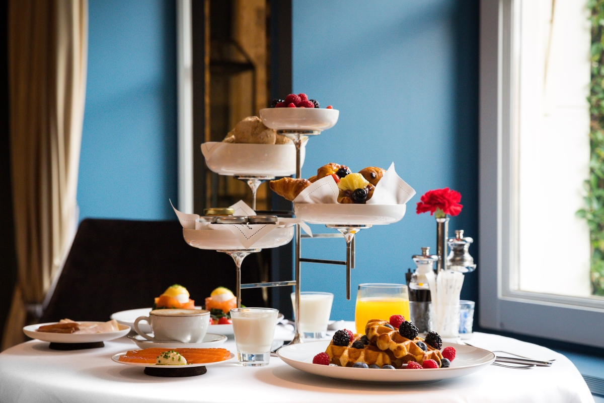 a tiered dessert stand with fruit and drinks on it