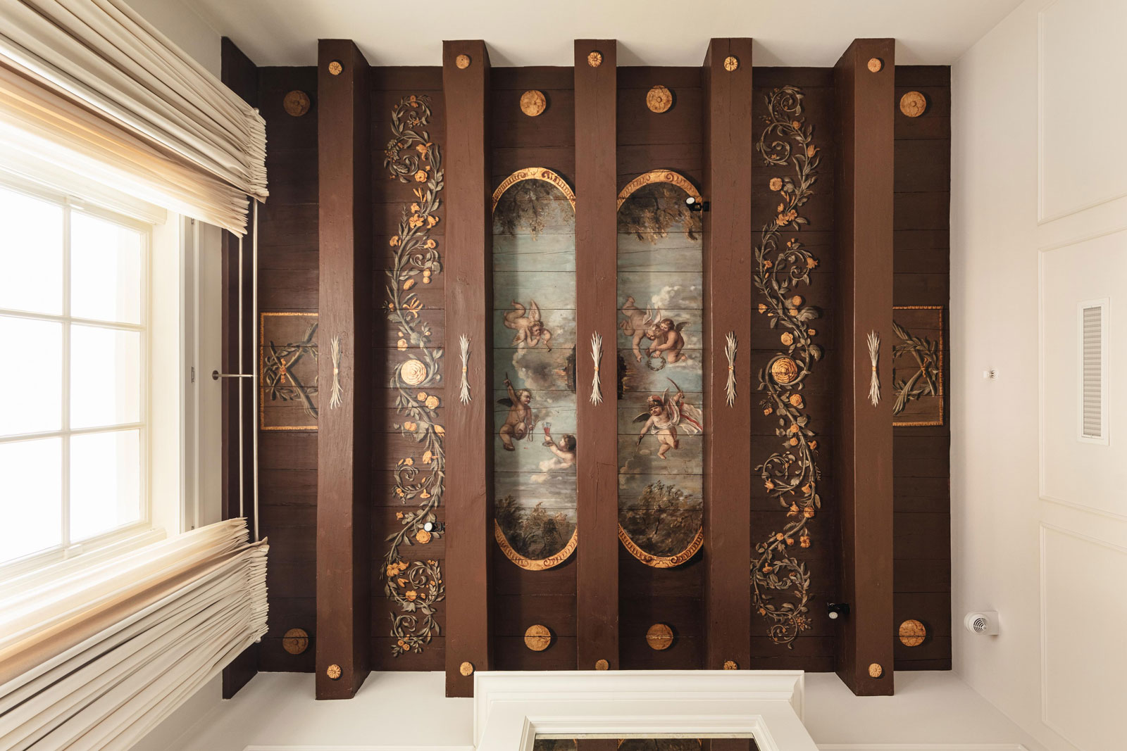 a wood paneled ceiling with paintings on it