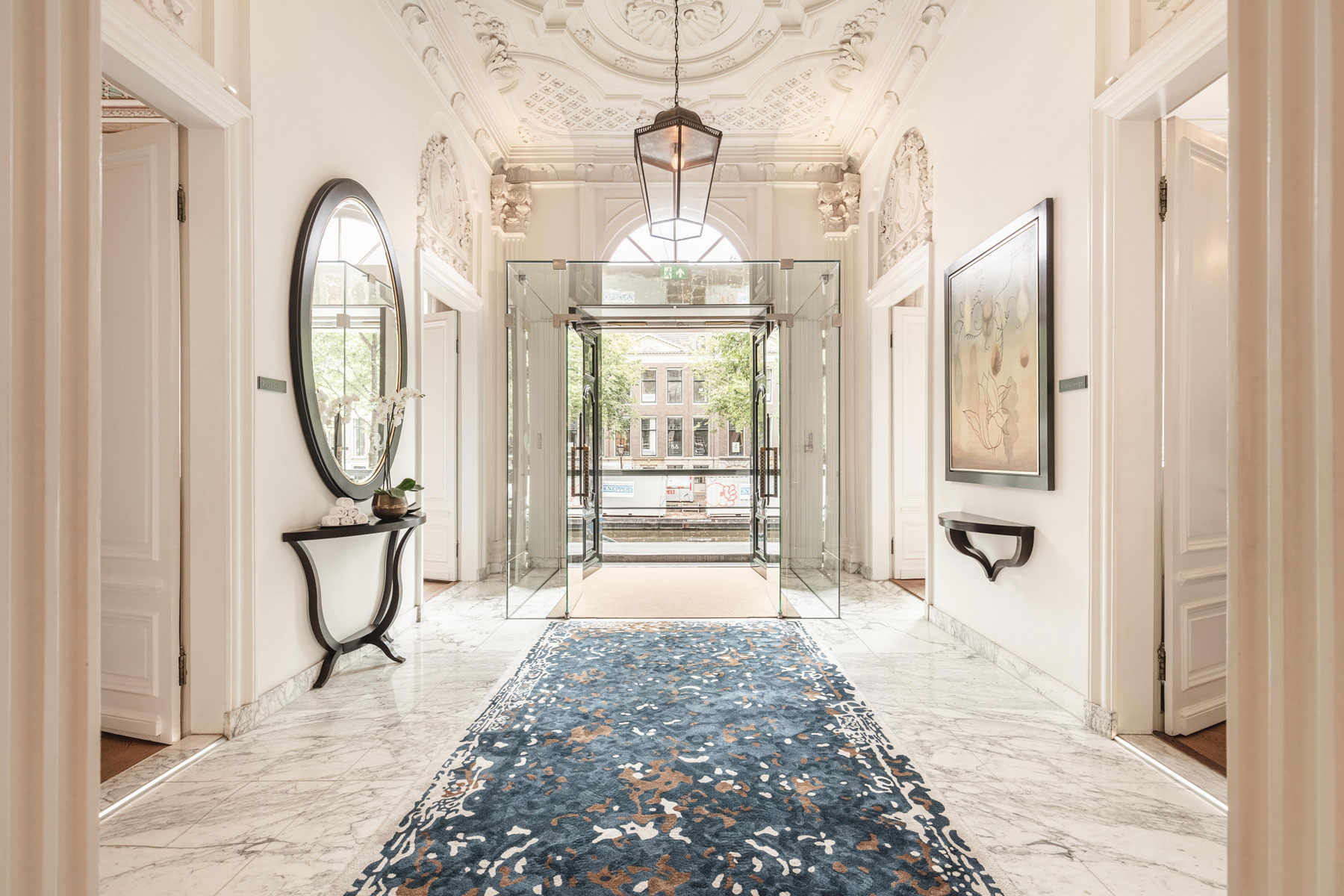 a hallway with a glass door and a rug