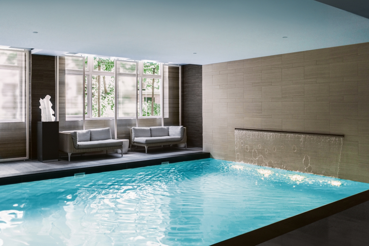 a indoor pool with a waterfall and a couches in the background