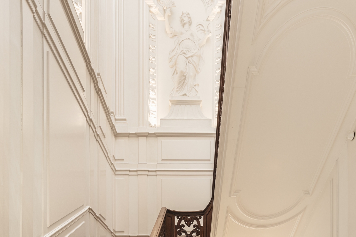 a staircase with a statue on the wall