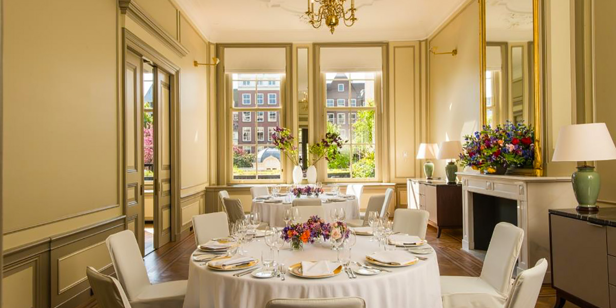 a room with a table set for a dinner party