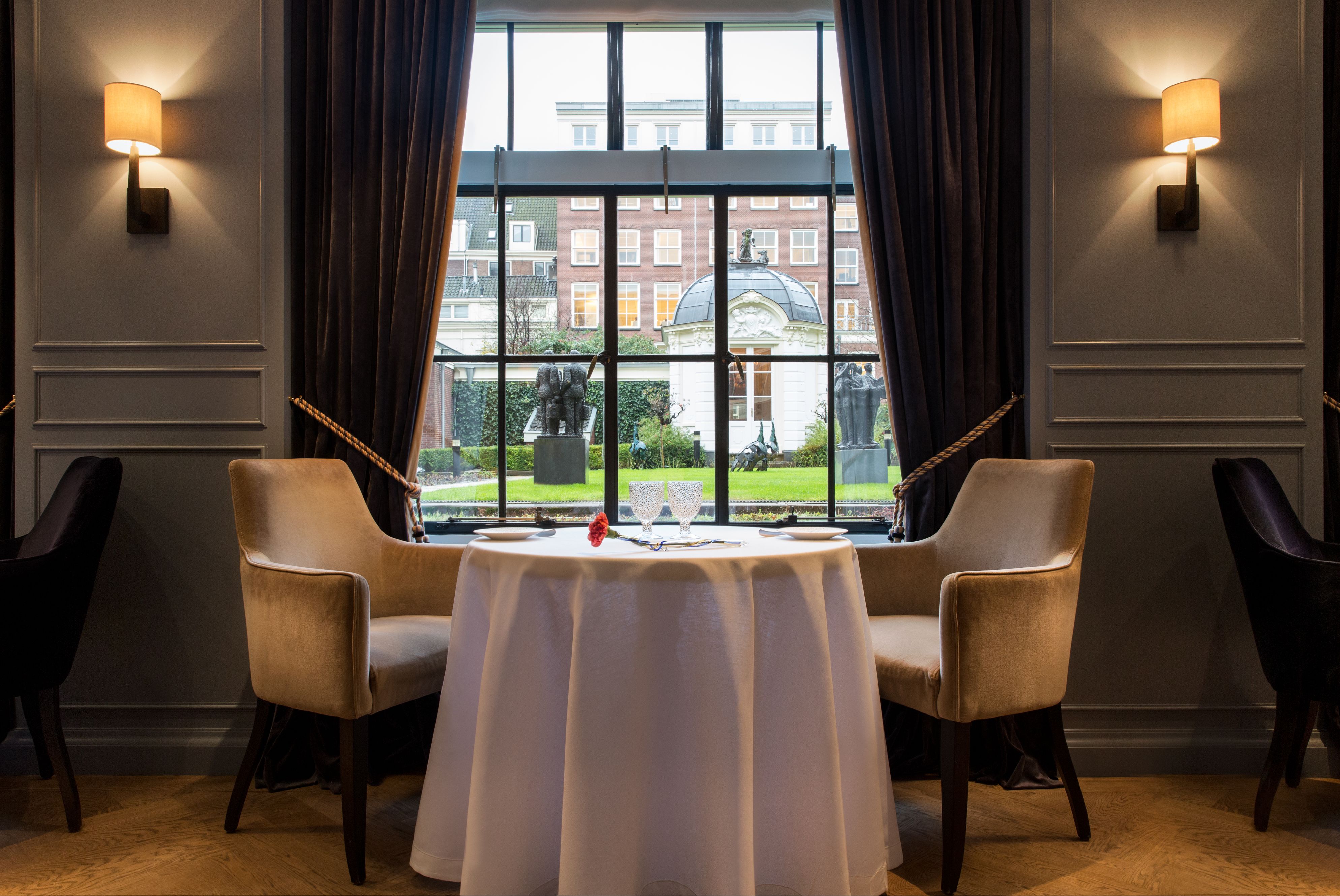 a table with chairs and a white tablecloth in front of a window