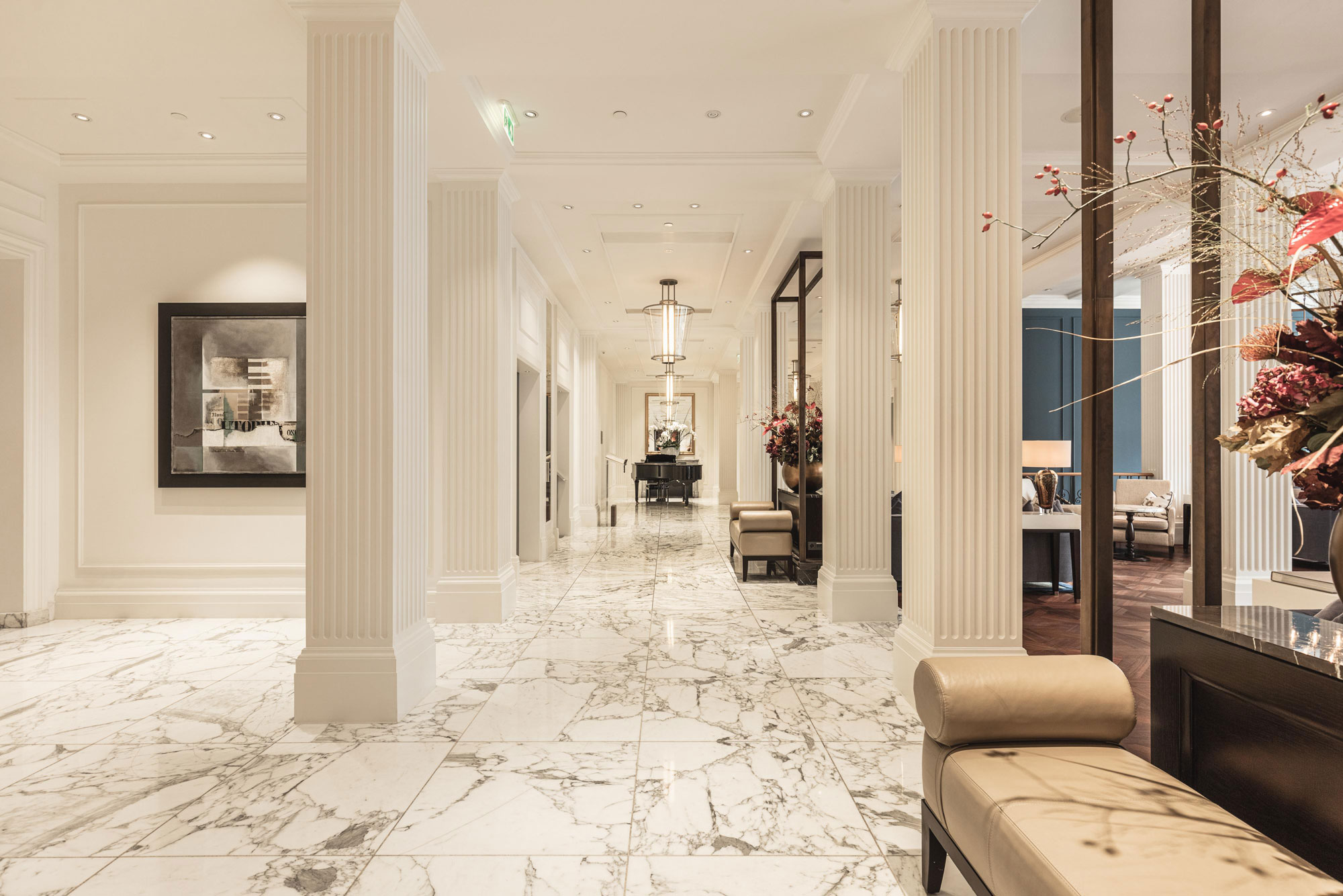 a hallway with white columns and a couch