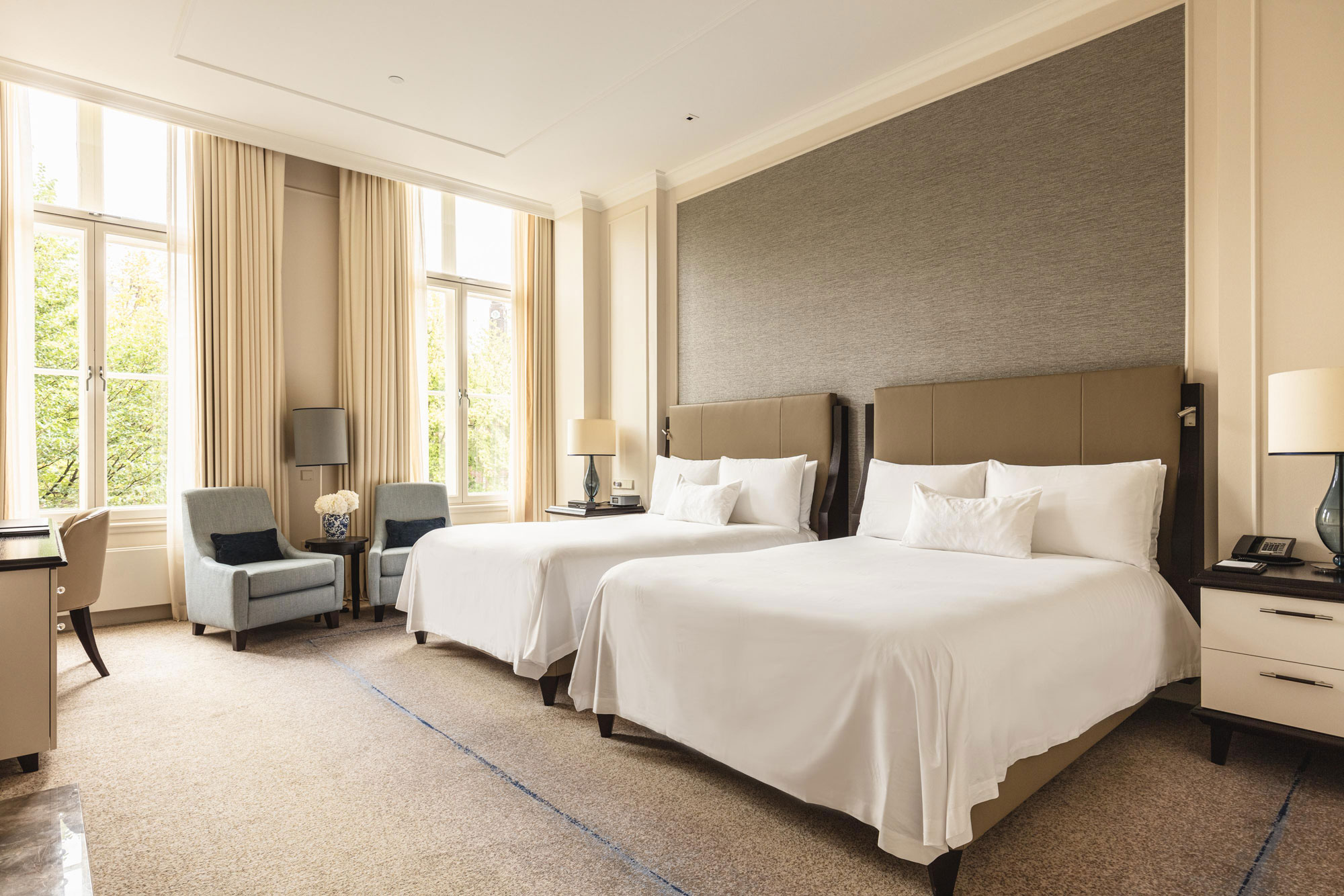 a room with two beds and a chair