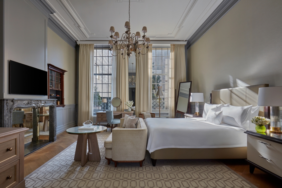 a bedroom with a large bed and a chandelier