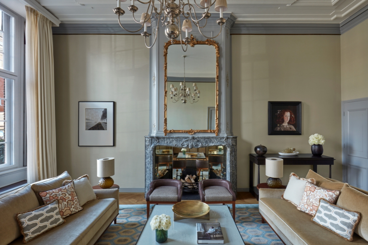 a living room with a fireplace and chandelier