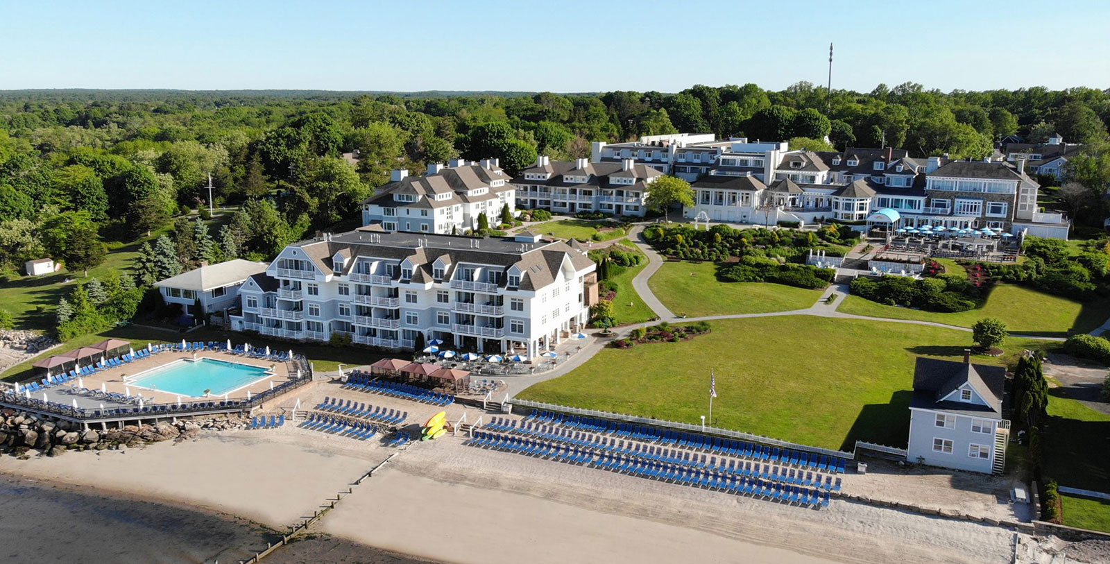 a large white building with blue chairs and lawns