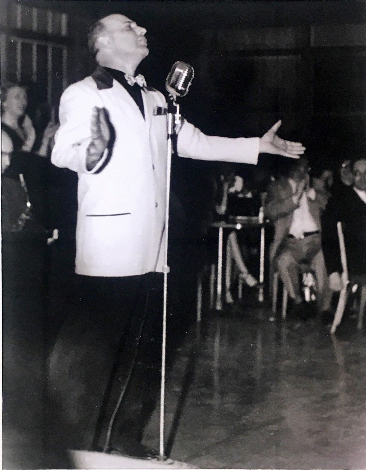 a man in a white suit with a microphone