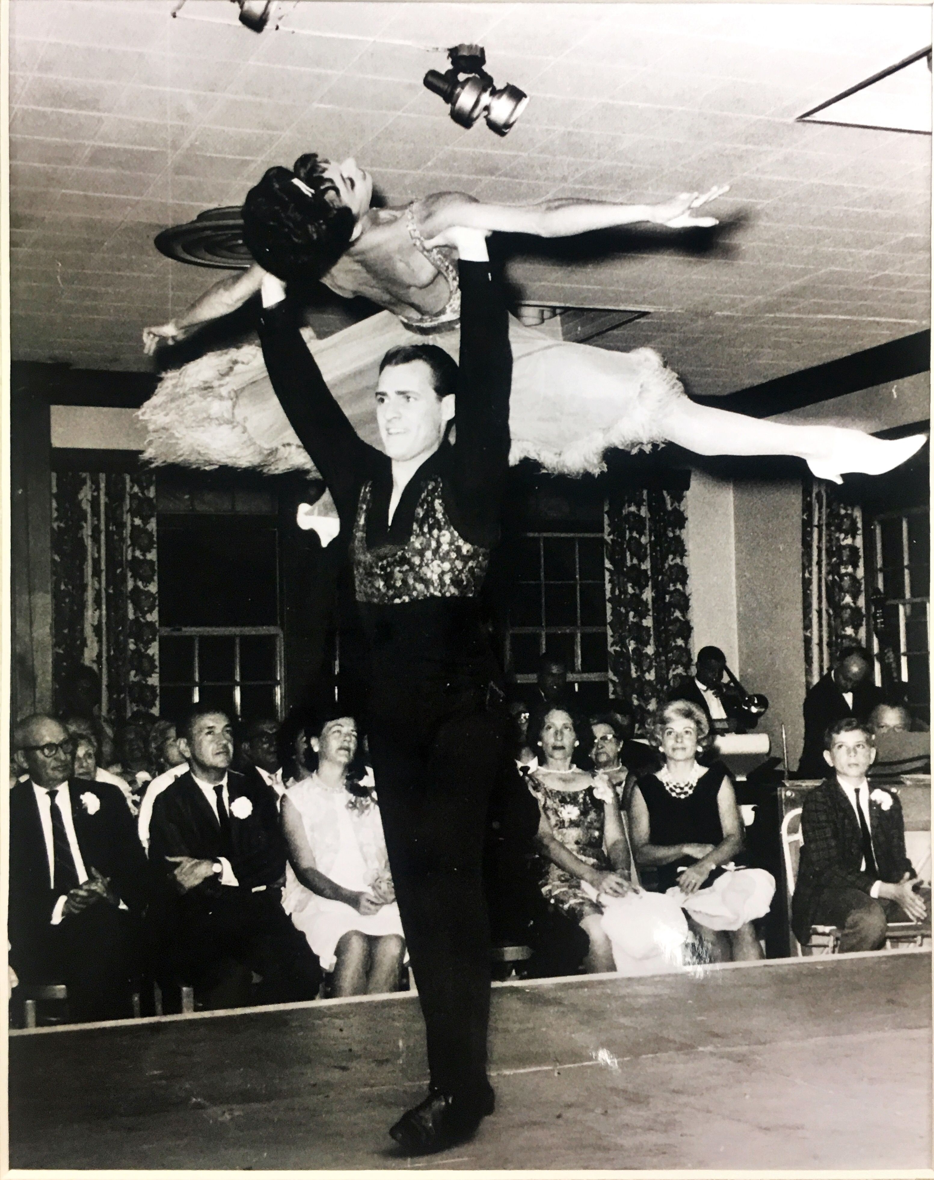 a man and woman dancing in a room with people watching
