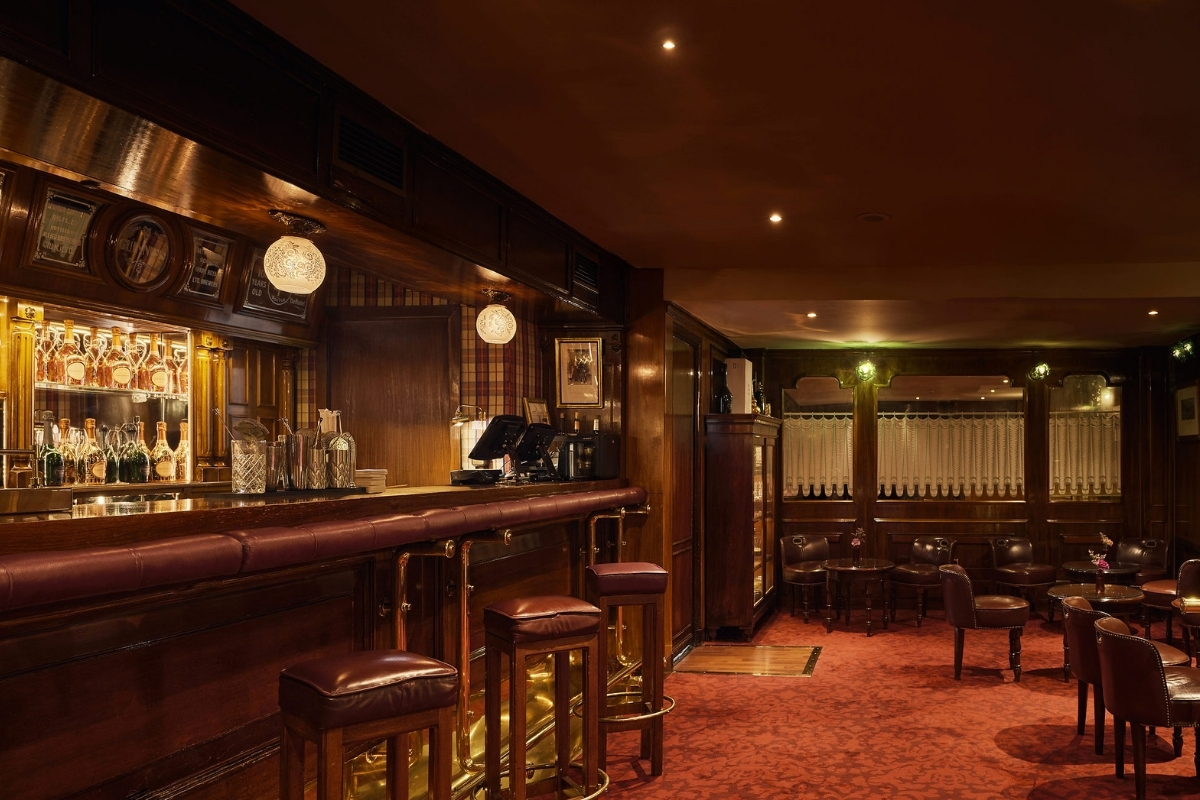 a bar with chairs and a red carpet