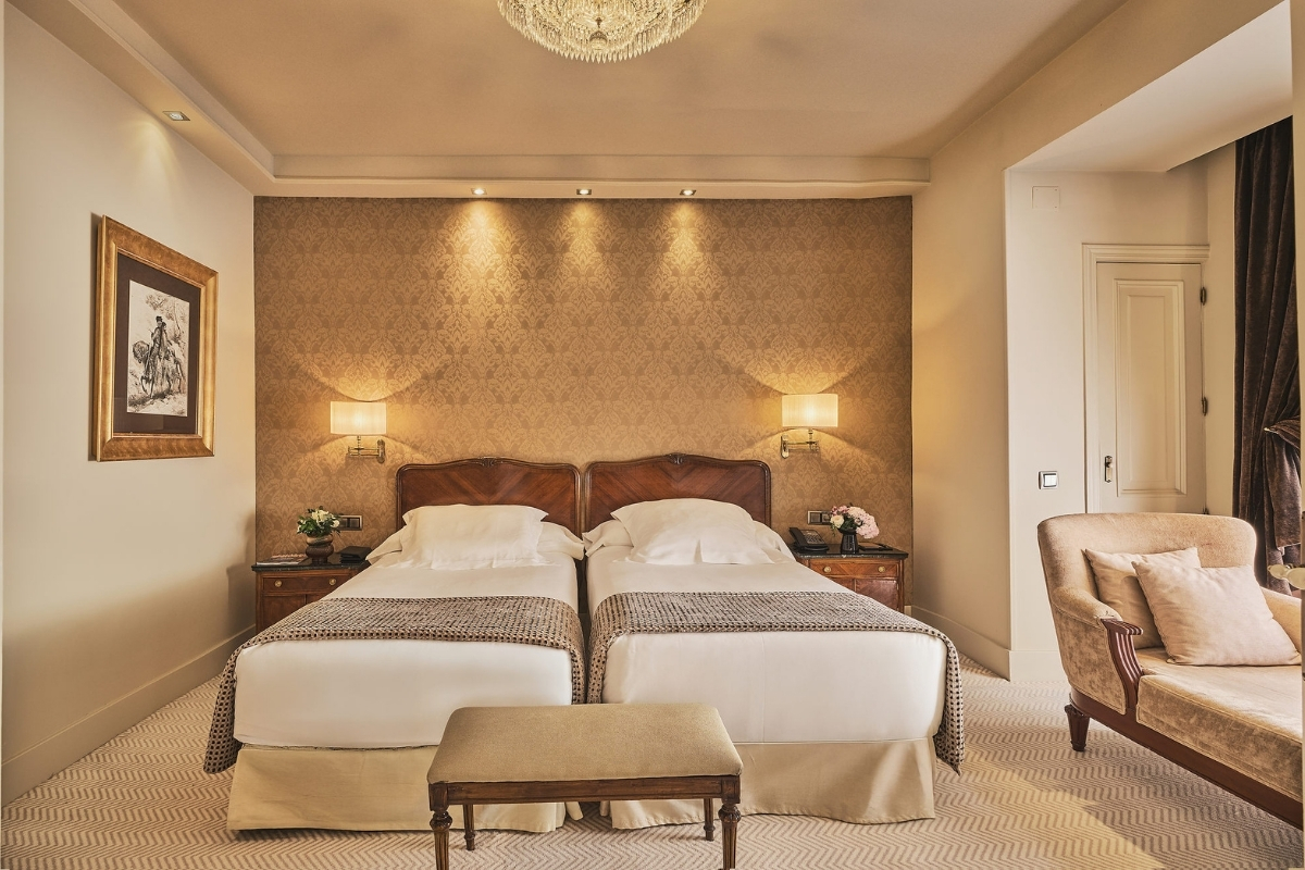 a bedroom with two beds and a chandelier