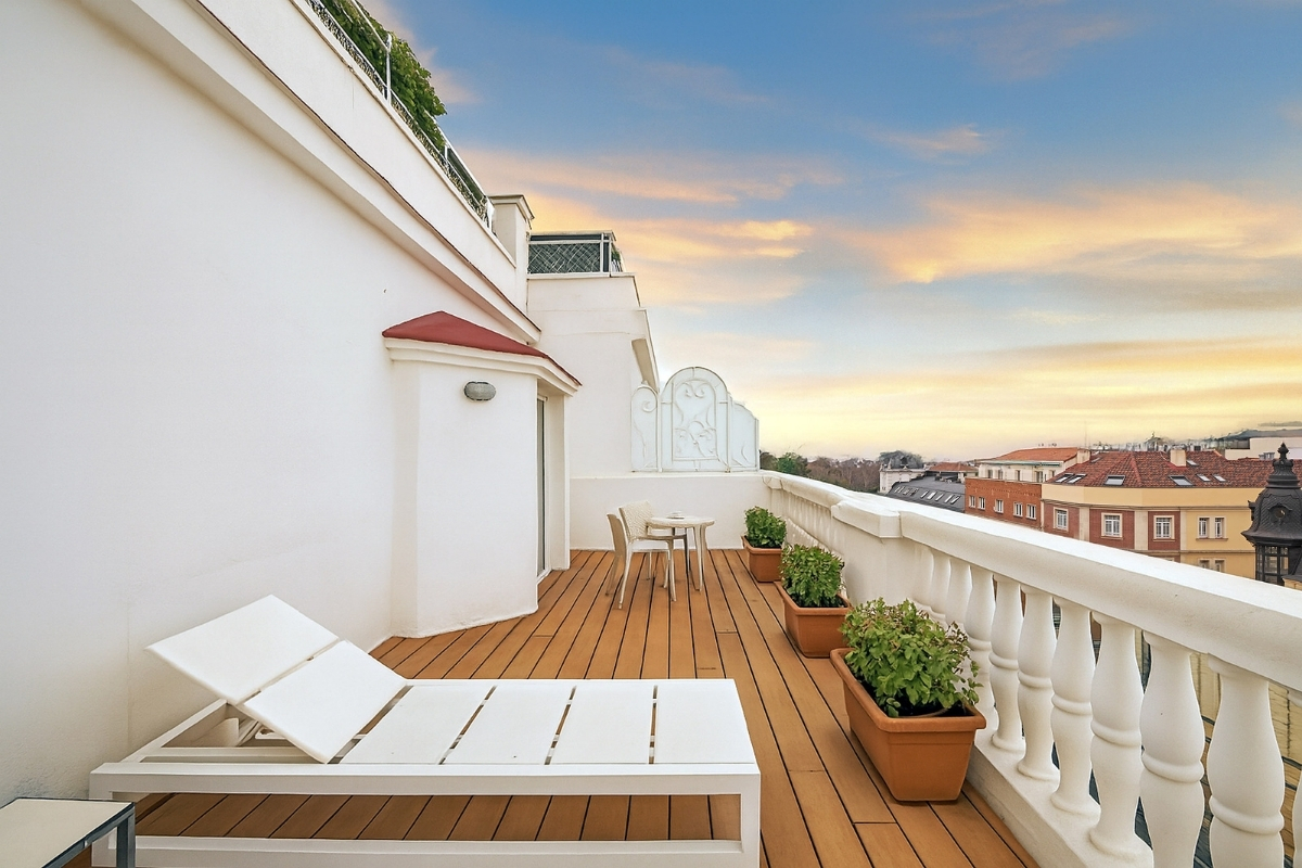a deck with chairs and potted plants on it