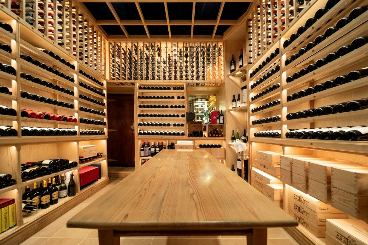 a wine cellar with a table and many bottles of wine