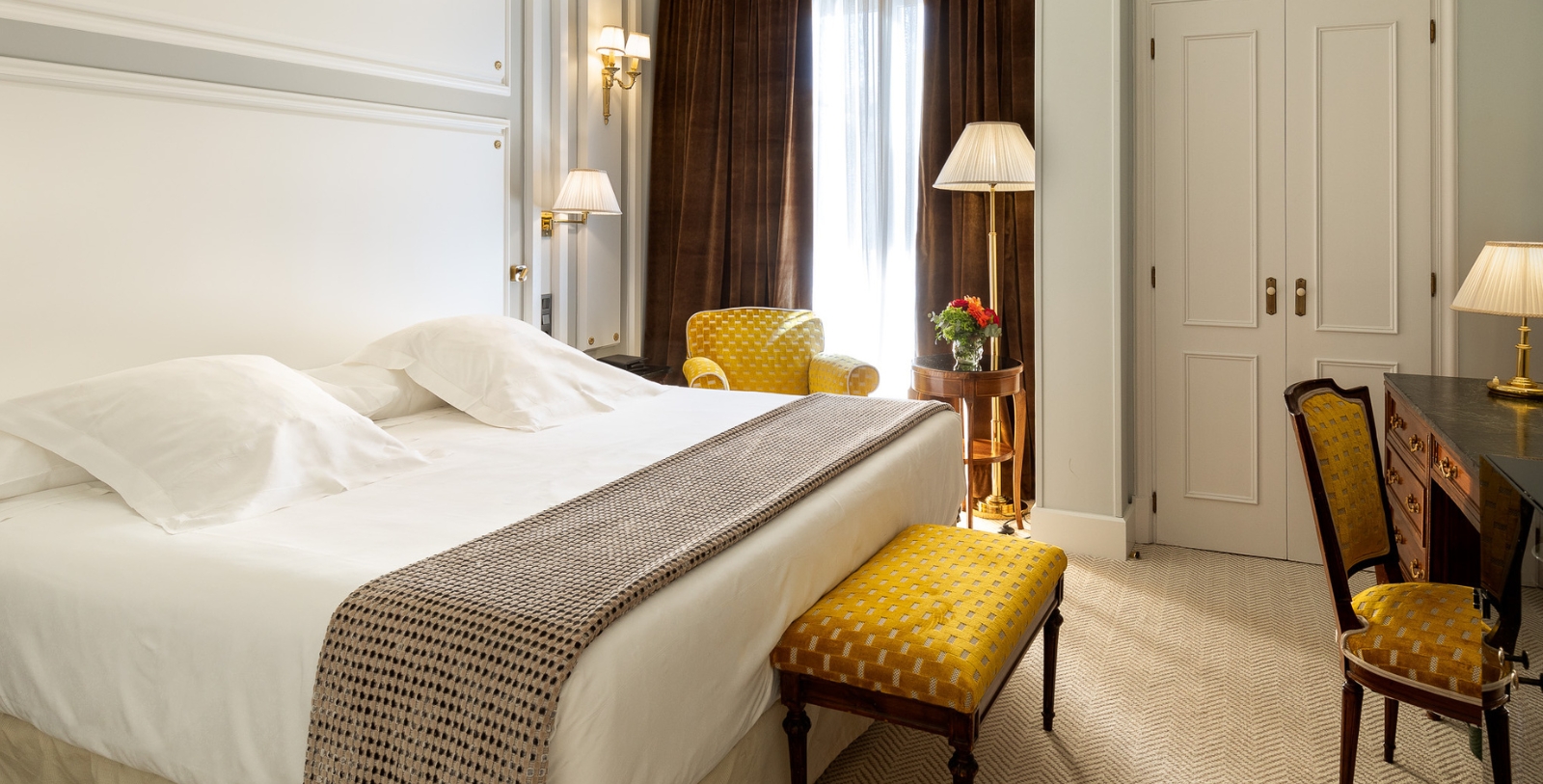 a bed with a yellow chair and a lamp