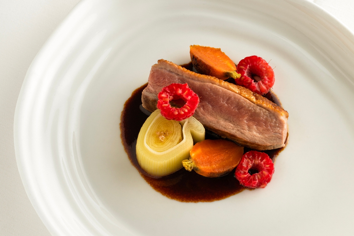 a plate of food with sauce and fruit