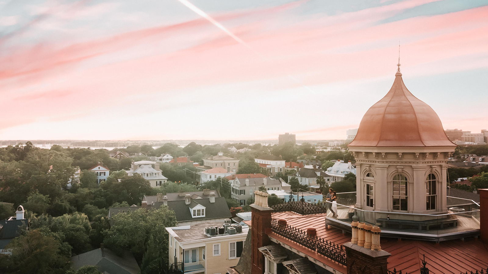 a rooftop of a building with a dome roof and a city in the background