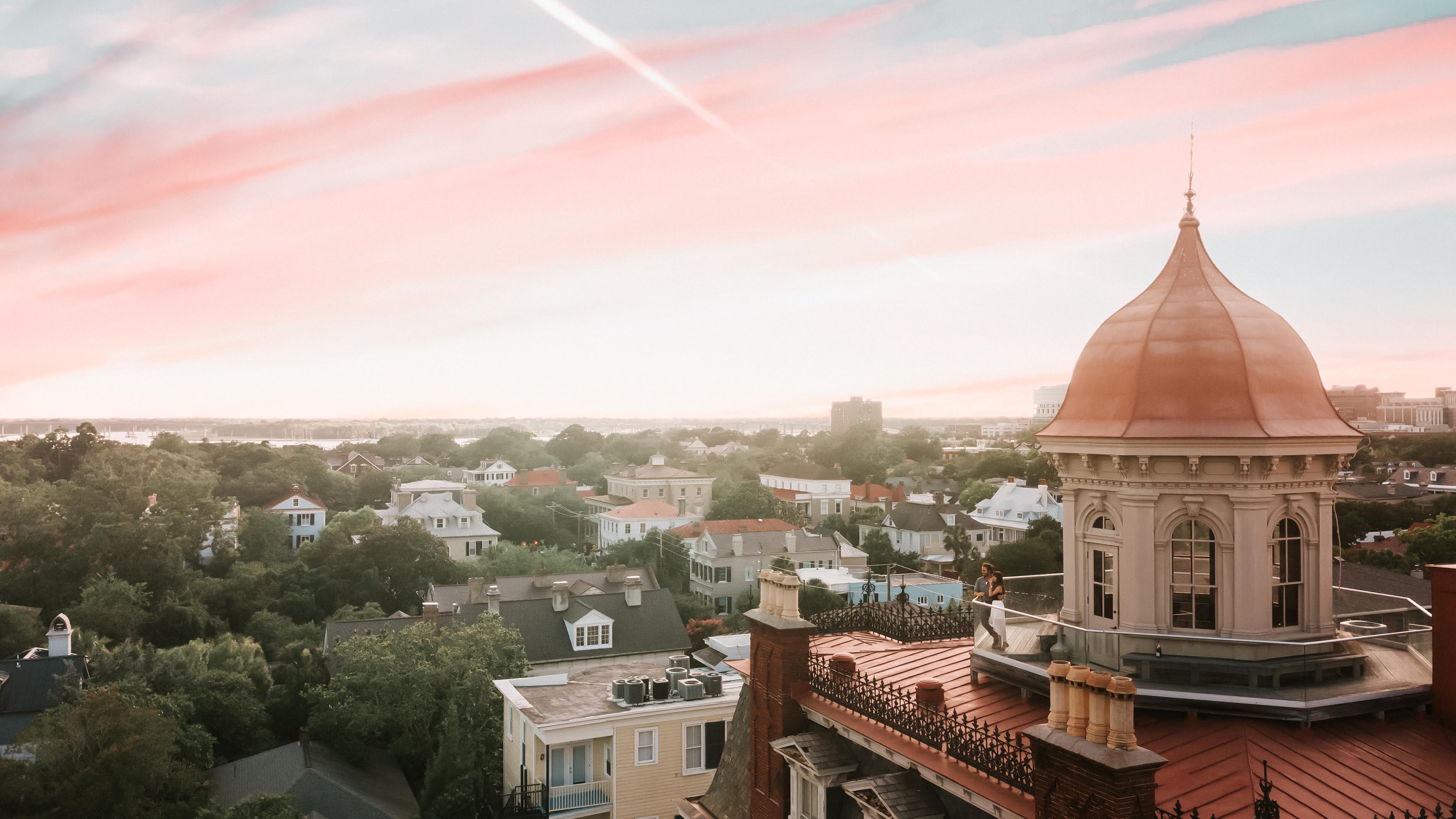 a rooftop of a town with a person standing on a roof