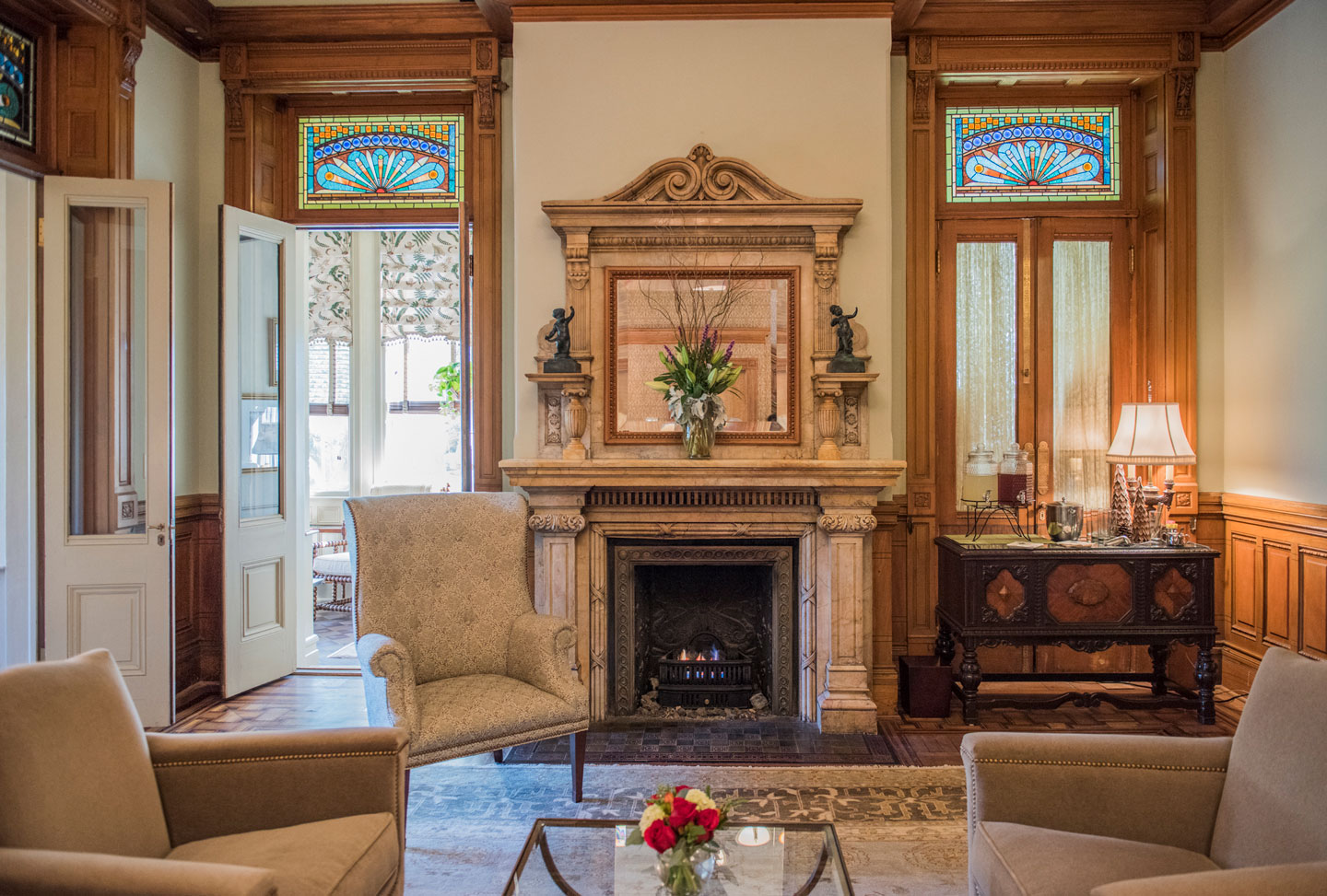 a living room with a fireplace and chairs