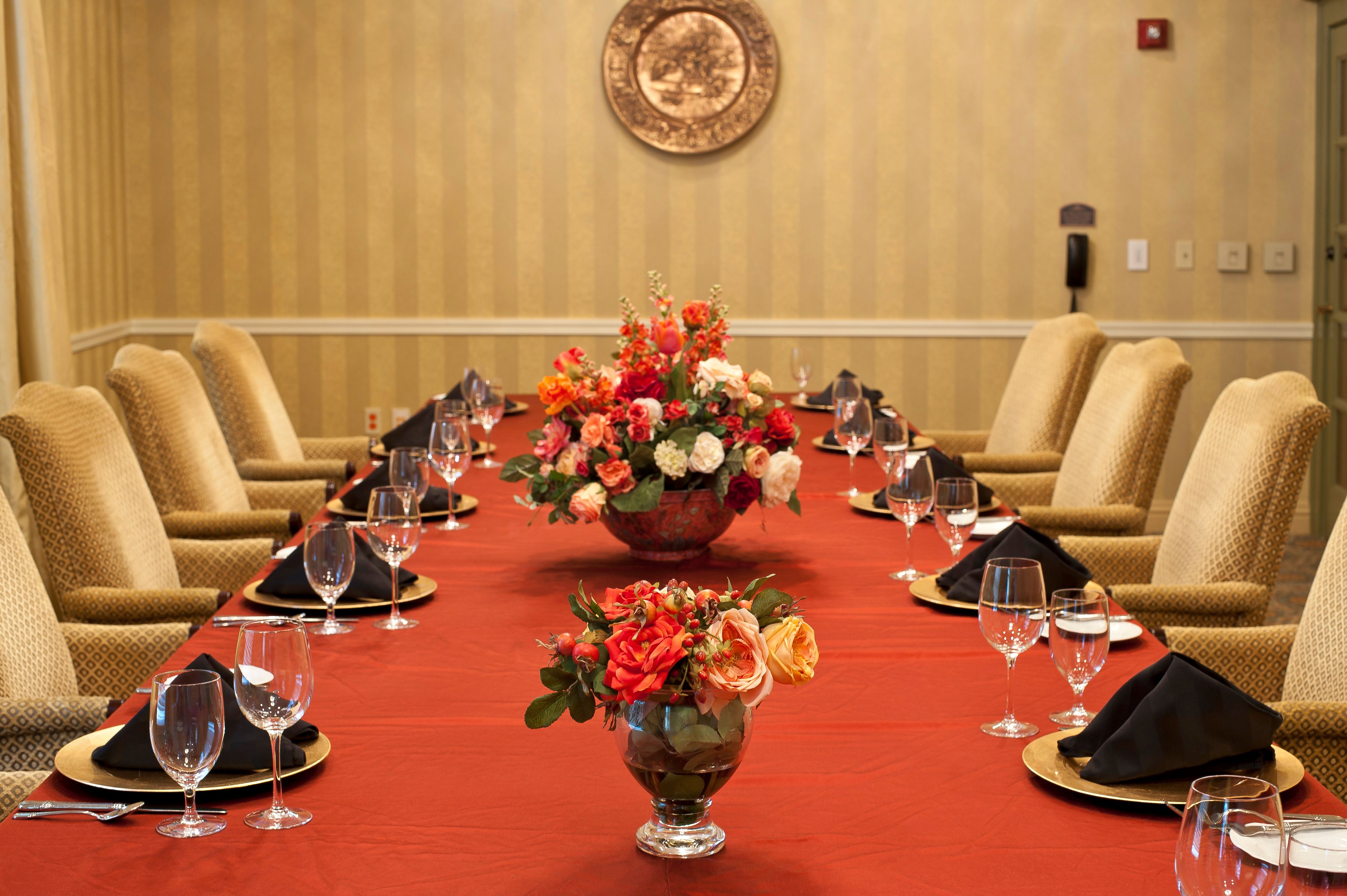 a table with a red tablecloth and flowers