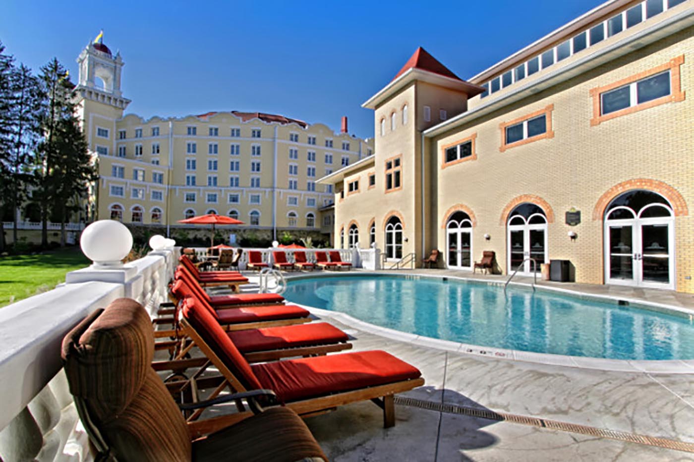 a pool with chairs and a building