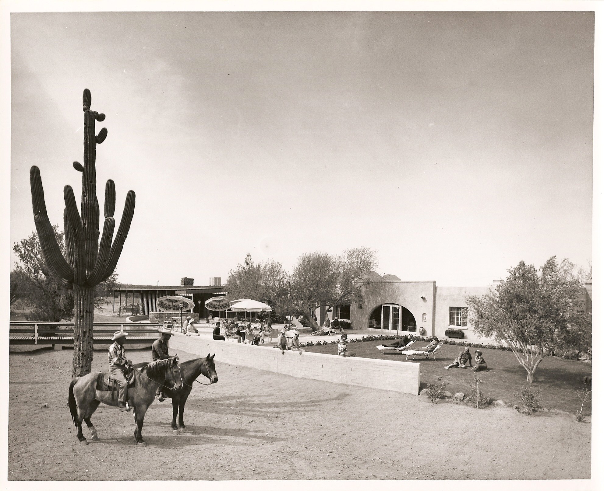 a group of people riding horses in a desert
