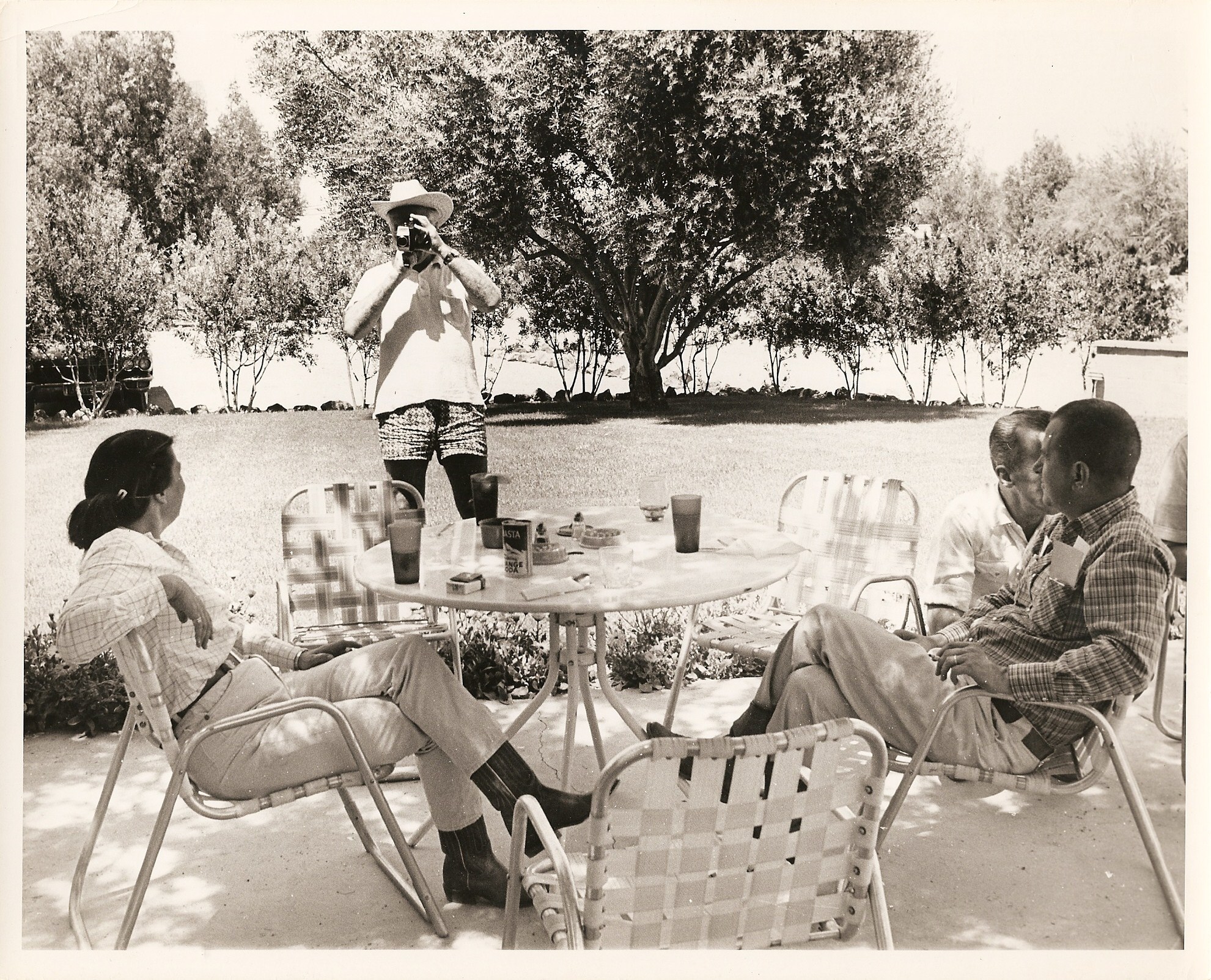 a man taking a picture of a group of people sitting around a table